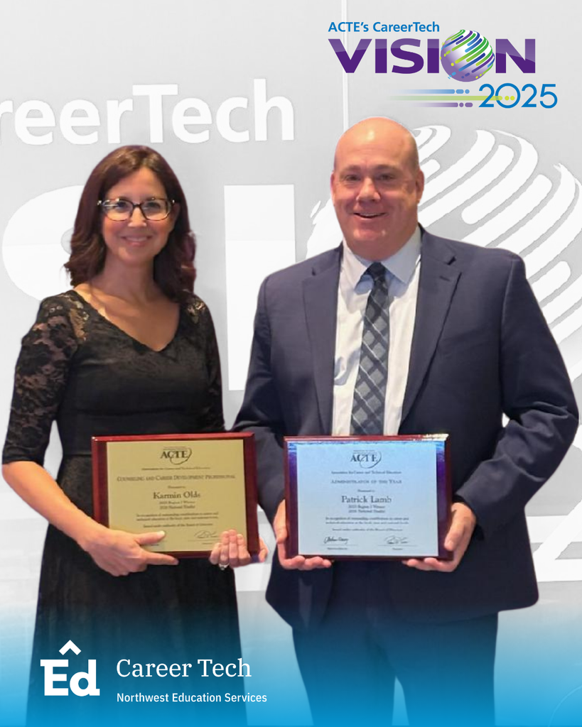 Two adults stand side by side, smiling and holding framed award plaques at the ACTE CareerTech VISION 2025 conference. The person on the left wears a black dress and glasses; the person on the right wears a navy suit with a patterned tie. Behind them is a gray backdrop with “CareerTech VISION 2025” branding and a globe graphic. A blue overlay at the bottom displays the North Ed Career Tech and Northwest Education Services logo.