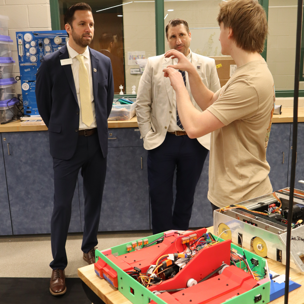 Engineering Academy student presenting their robot project to Matt Fortescue and Dr. Rob Kniss.