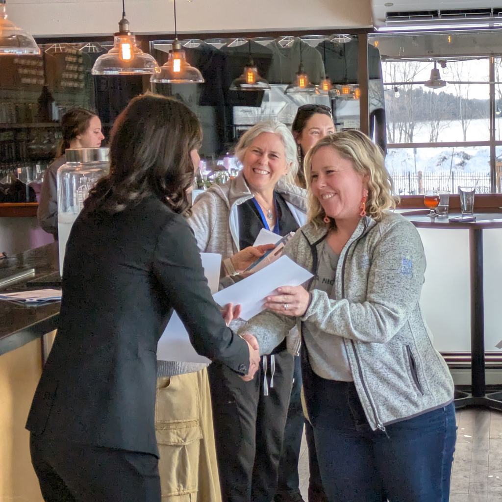 Angie Nichols smiling while receiving her certificate from Dr. Tara Mager