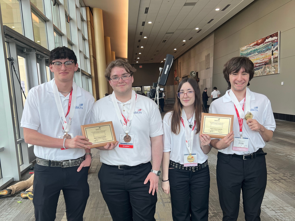 Four Career Tech Film & New Media students wearing white polos and black pants posing with their awards at 2026 SkillsUSA Michigan