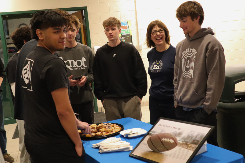 Career Tech students and school social worker Laura Miller gathered around a table at the ‘Stories from a Stranger’ gallery on exhibit at Career Tech. 