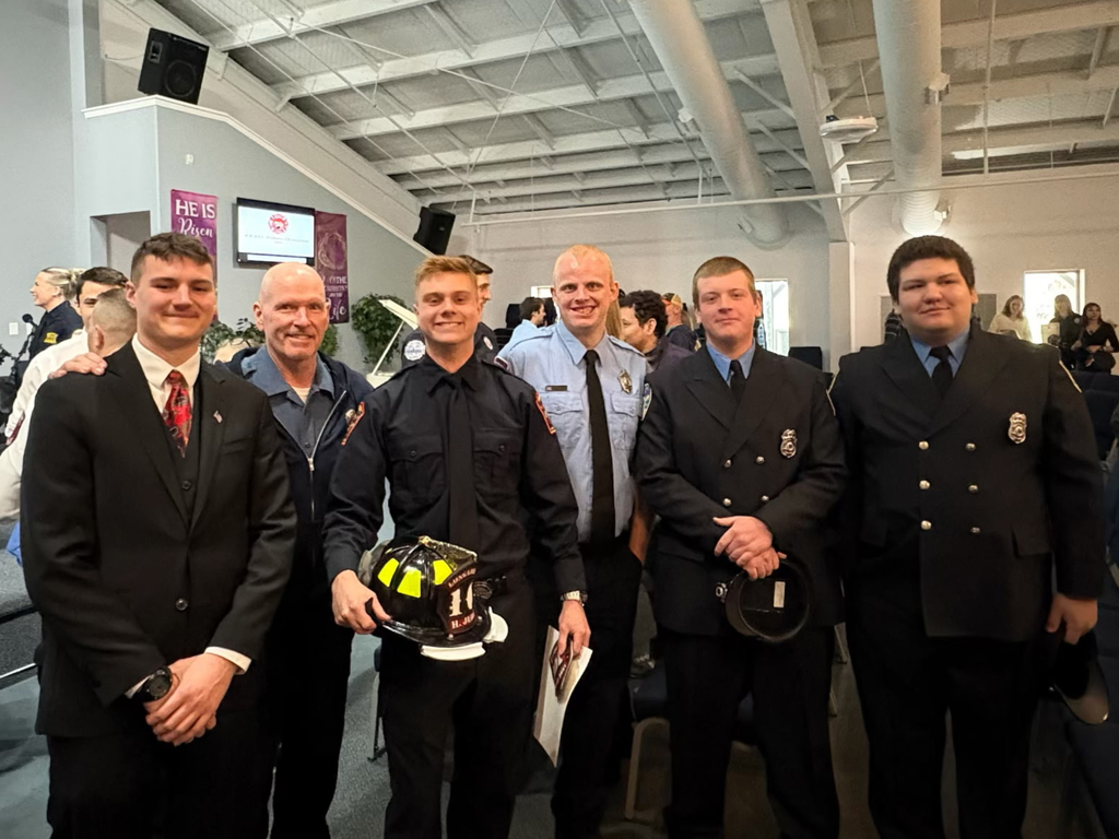 Public Safety instructor Tom Lennox, current student Hayden Jury, and former Public Safety students pose for a group photo at the Northwest Regional Fire Training Center graduation ceremony. 