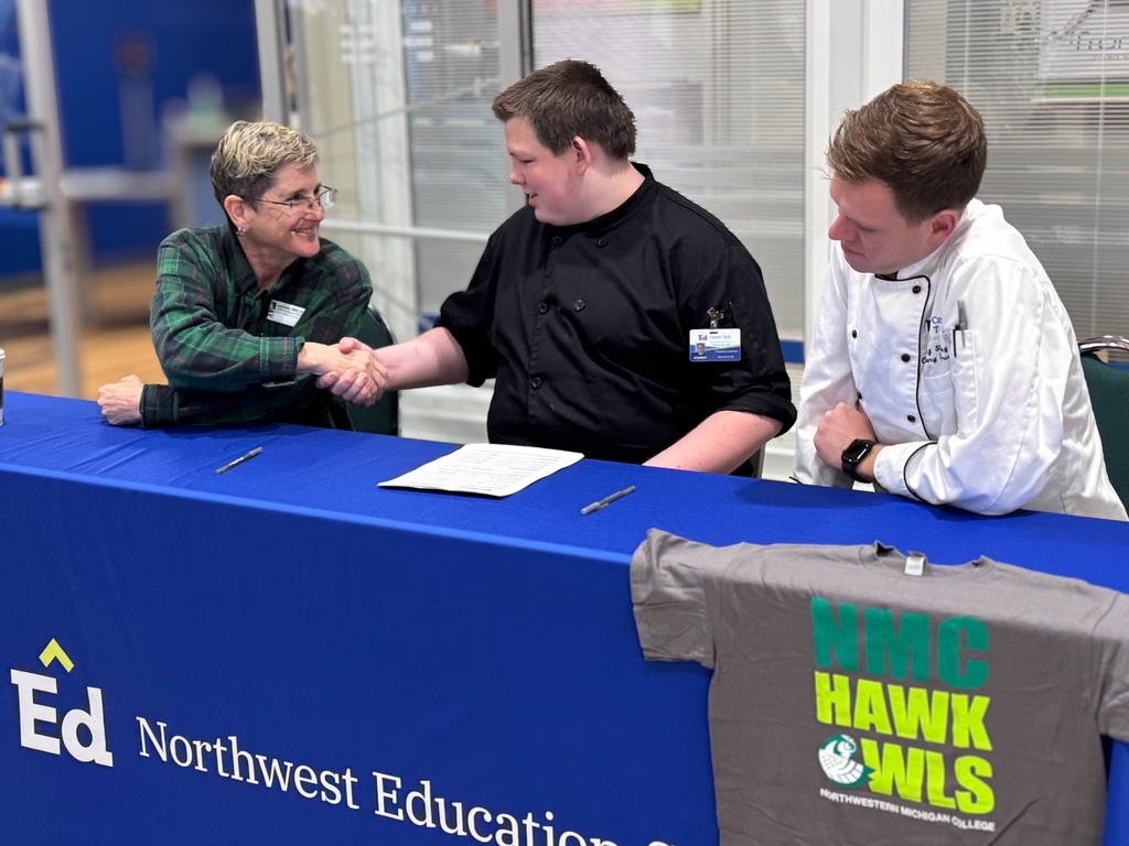 North Ed Career Tech student shaking hands with Northwestern Michigan College representative after signing articulation agreement.