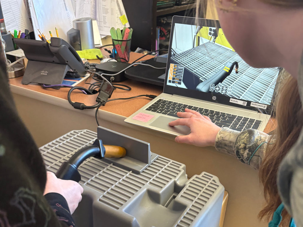 North Ed Career Tech welding student demonstrating a computer simulation for a 4th grader at Cherry Knoll Elementary. 