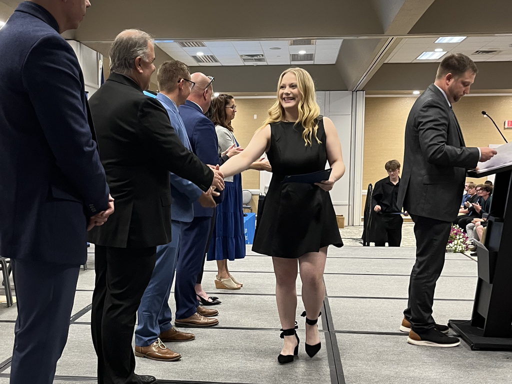 North Ed Career Tech student wearing a black dress, shaking hands with administrators as they walk across the stage at North Ed Career Tech Awards Night. 