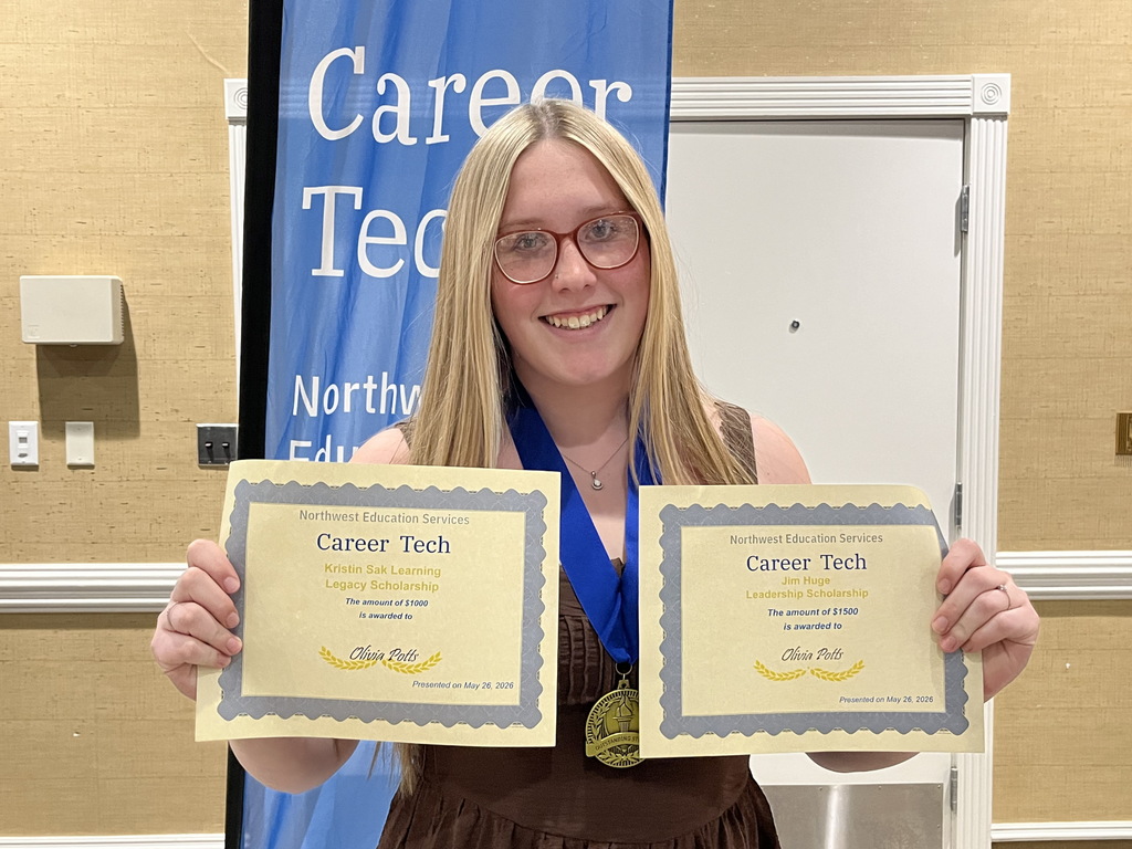 North Ed Career Tech student smiling, posing for a photo, holding two scholarship certificates at North Ed Career Tech Awards Night. 