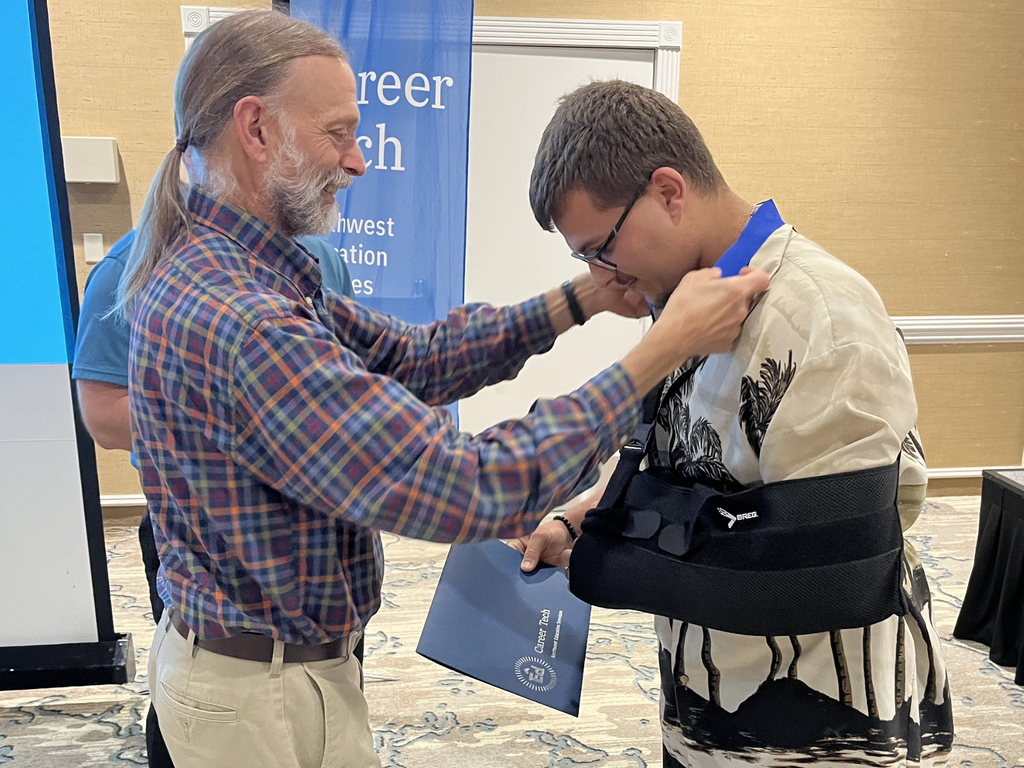 North Ed Career Tech instructor placing a medal around a student’s neck at North Ed Career Tech Awards Night. 