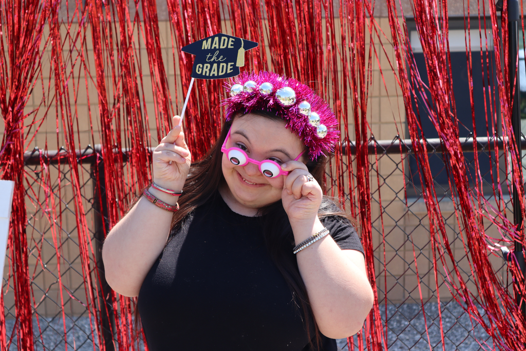 Transition Campus student posing with props in front of a photo backdrop at the annual picnic.