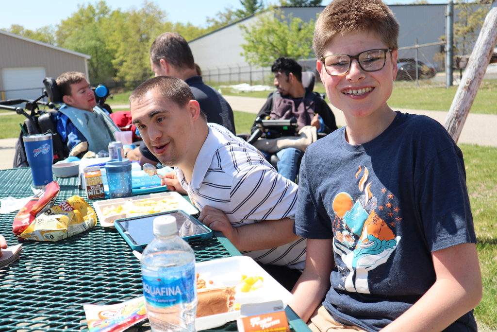 Multiple Transition Campus students smiling around a picnic table.
