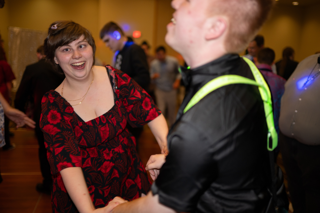 Two Transition Campus students smiling and holding hands while dancing at prom.