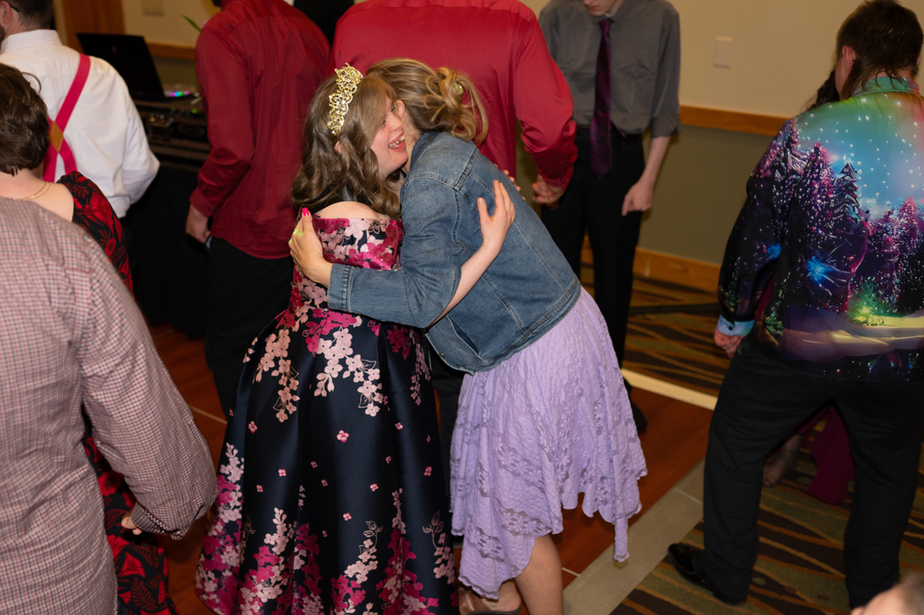 Transition Campus Prom Queen hugging prom attendee.