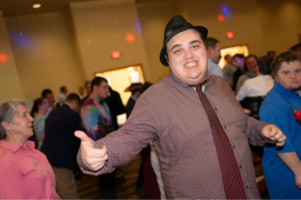 Transition Campus student smiling and gesturing at the camera on the prom dance floor.