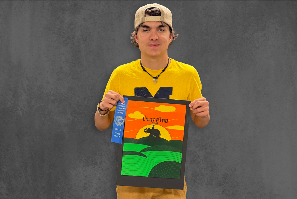 North Ed Career Tech Graphic Arts student Rylan Pickard posing, holding their award winning Screen Printing on Paper.