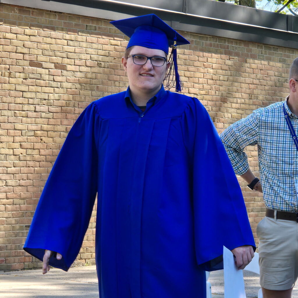 2026 Bridgeway Program graduate wearing a blue cap and gown for the ceremony. 