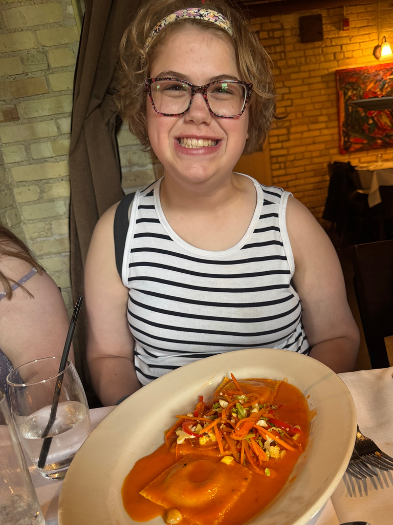 Transition Campus Work Experience Program student, smiling for a photo at lunch with their pasta dish.