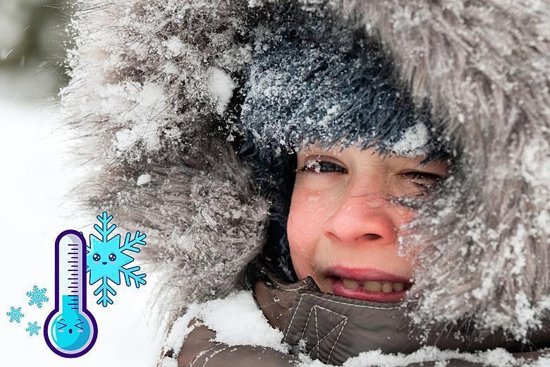 Kid dressed in coat with snow on hood