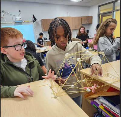 Boys conducting a science experiement with sticks and marshmallows