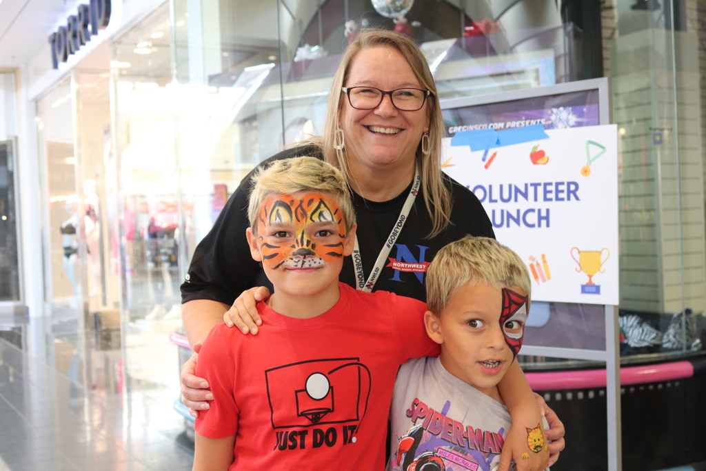 Mother and two children with face paint smiling at the camera at Health and Safety fair.
