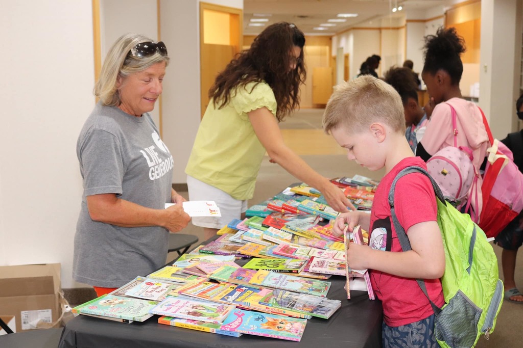 Children picking out books at Health and Safety fair.