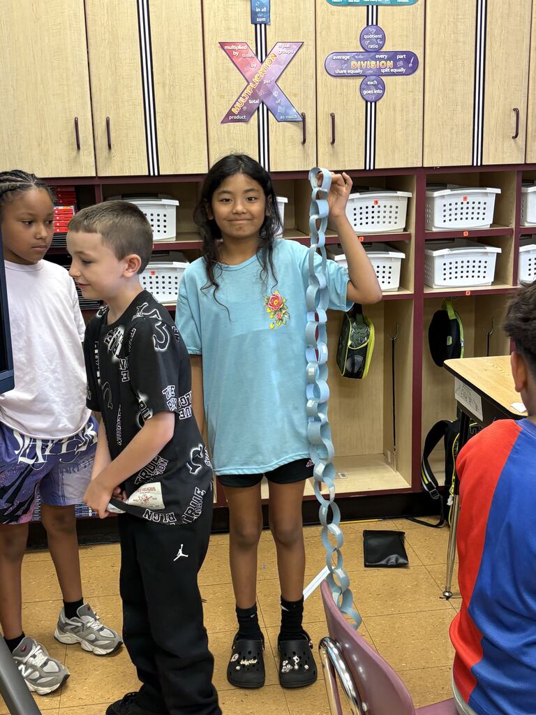 student holding up paper chain