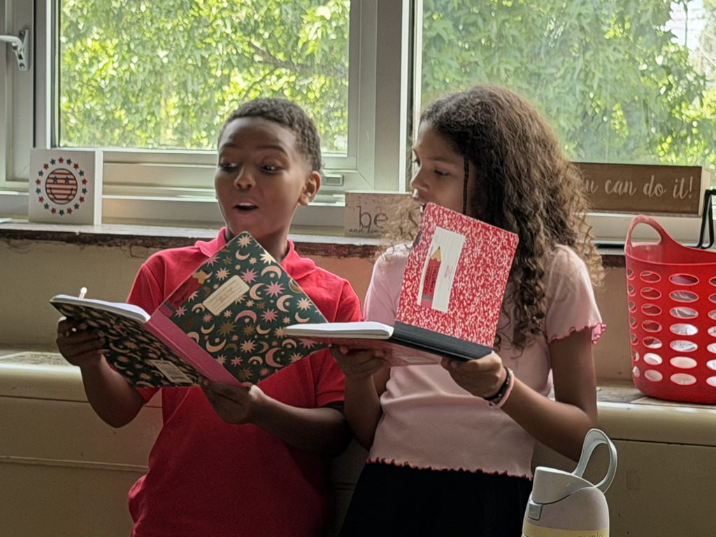 students reading from notebooks