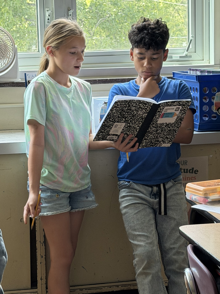 students reading from notebooks