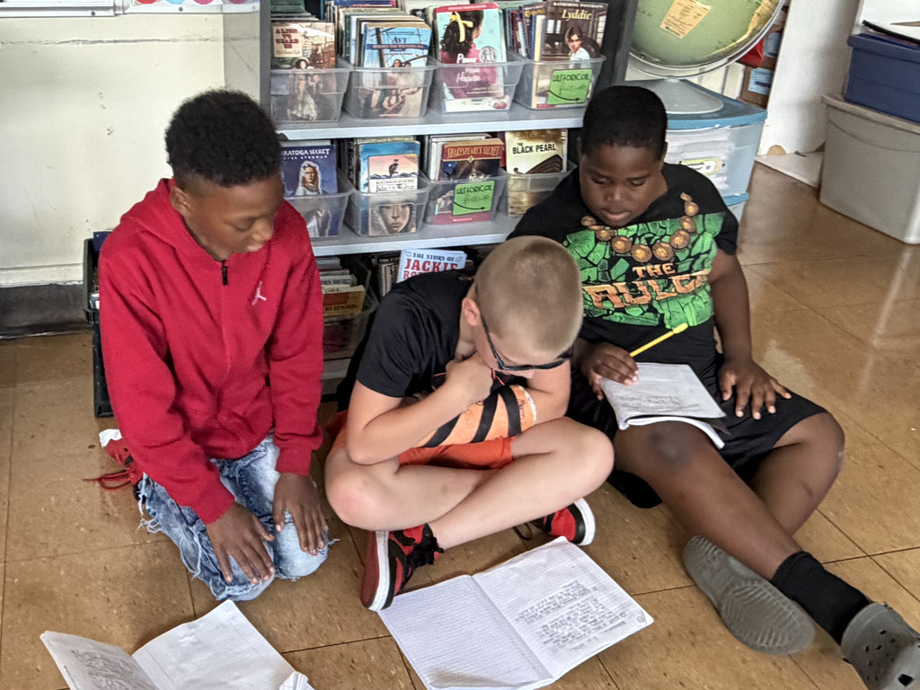 students sitting reading notebooks