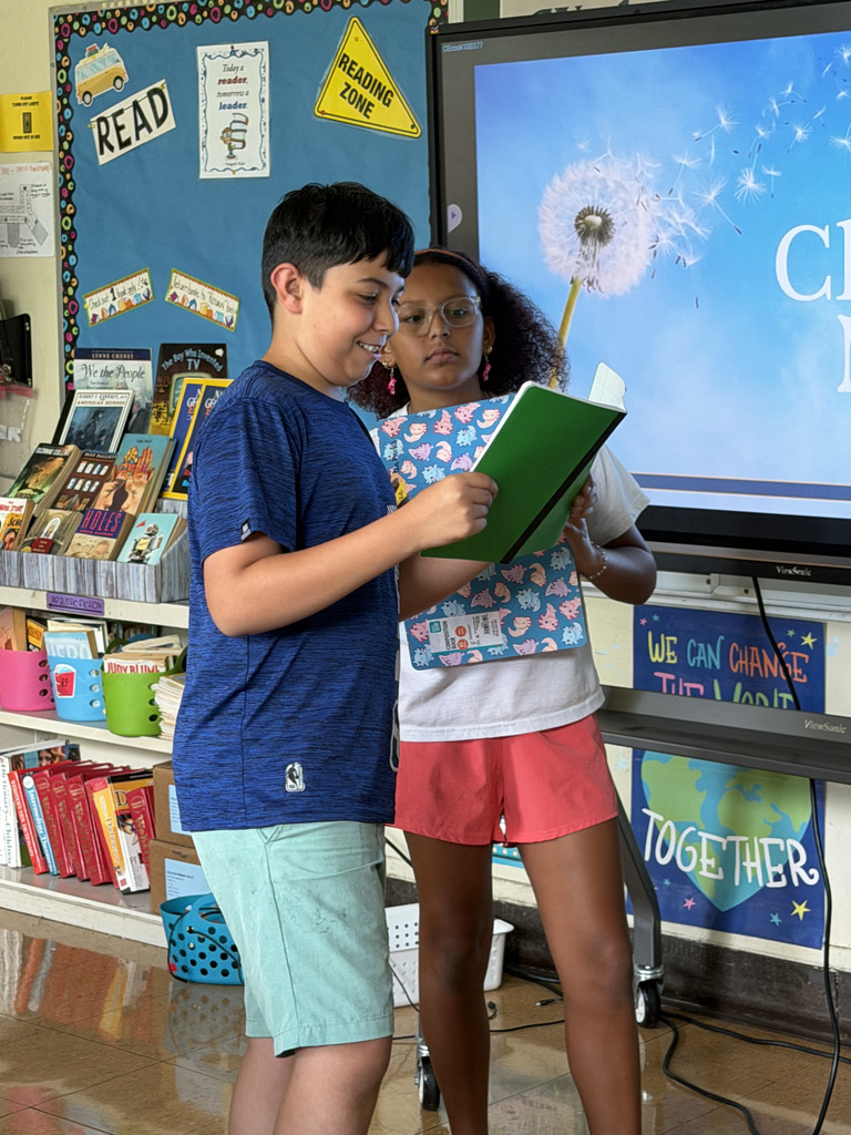students standing reading from note book