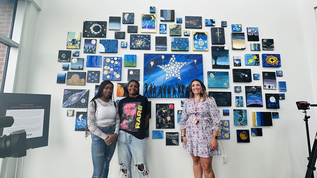 Photo of students and the CHS Principal standing in front of the artwall.