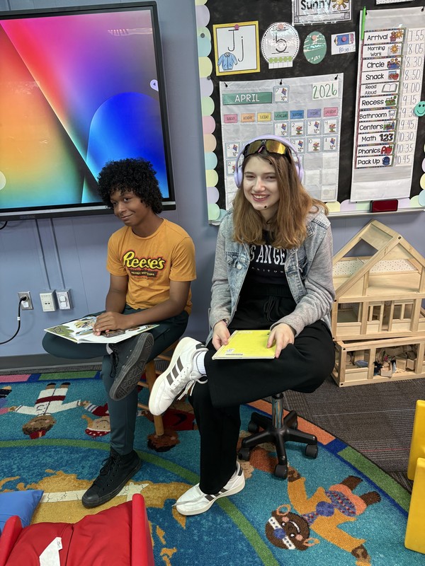 Two teens sit in the front of the class