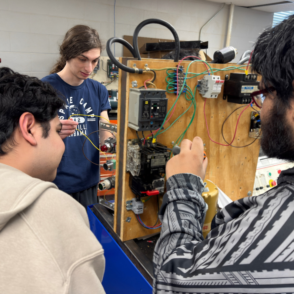 NWTI electronics and automation students work on a 3 phase motor control