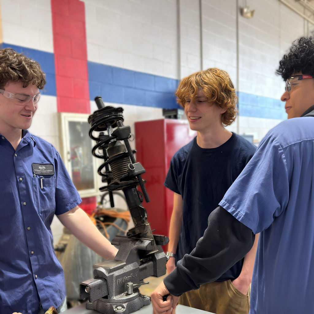Our high school automotive program students work on a strut coil