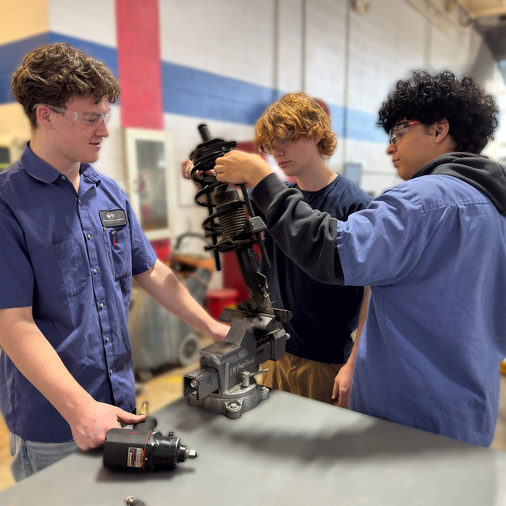 Our high school automotive program students work on a strut coil