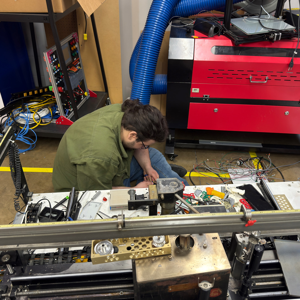 electronics and automation student and instructor work on a soldering machine
