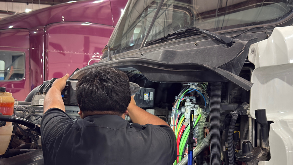 Diesel Truck tech student works inside a big rig engine