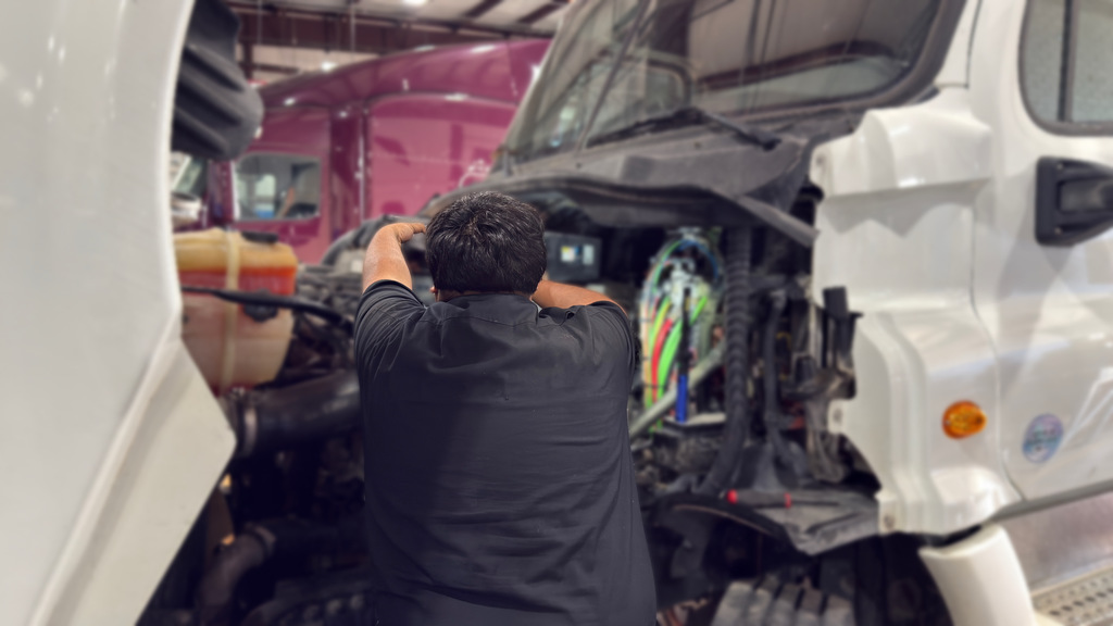 Diesel Truck tech student works inside a big rig engine