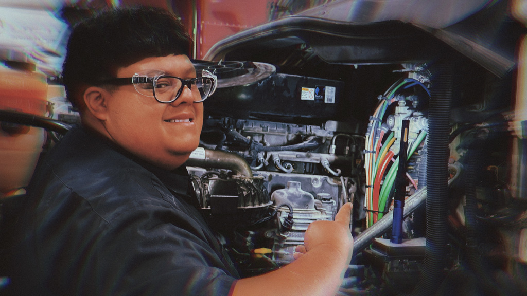Diesel Truck tech student works inside a big rig engine