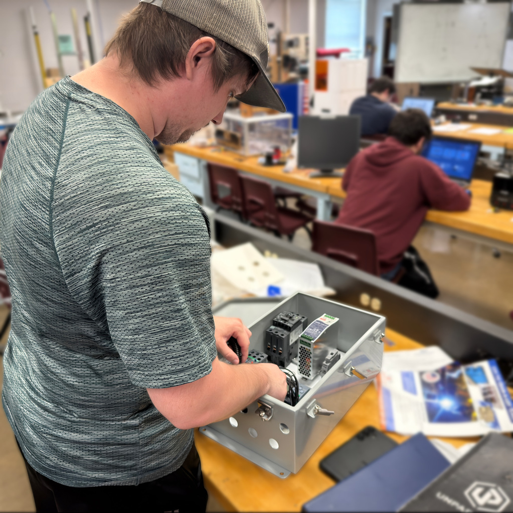 Electronics student Garrett Burger works on a control panel