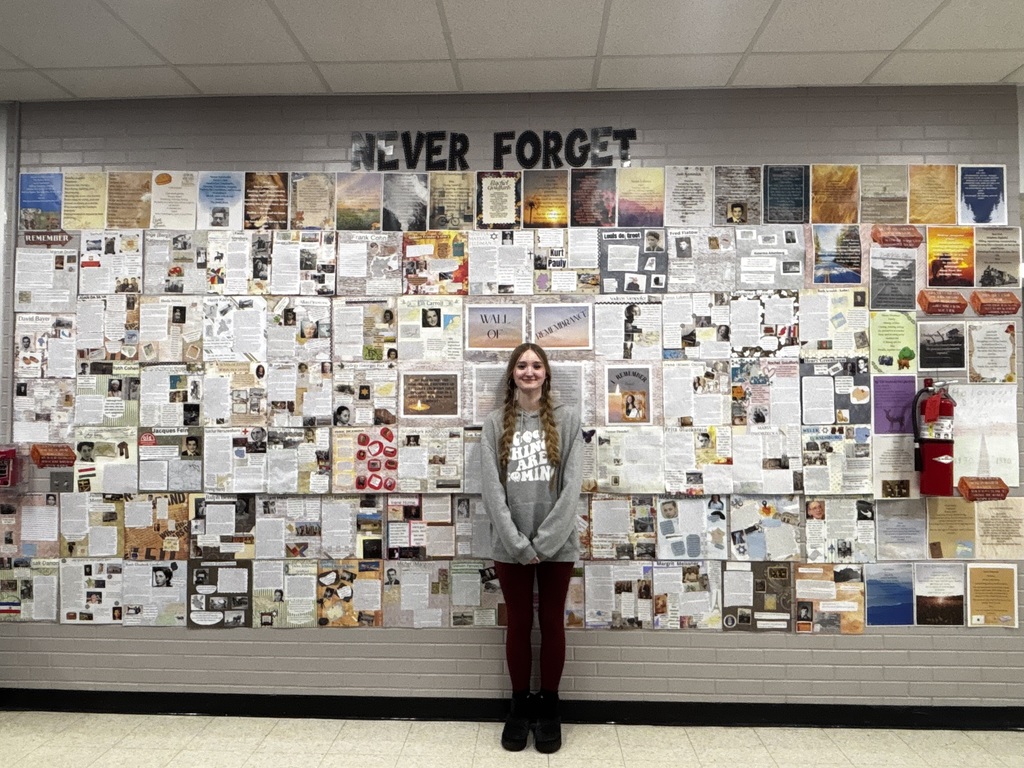 Student in front of Never Forget display