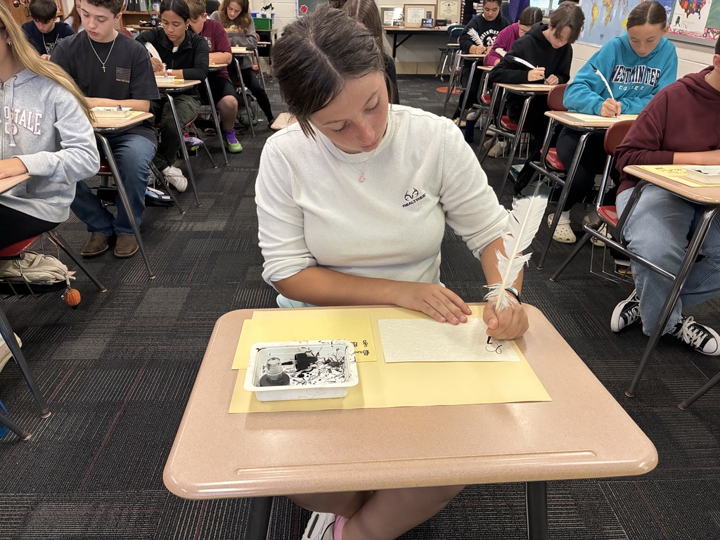 Middle school students writing with quills