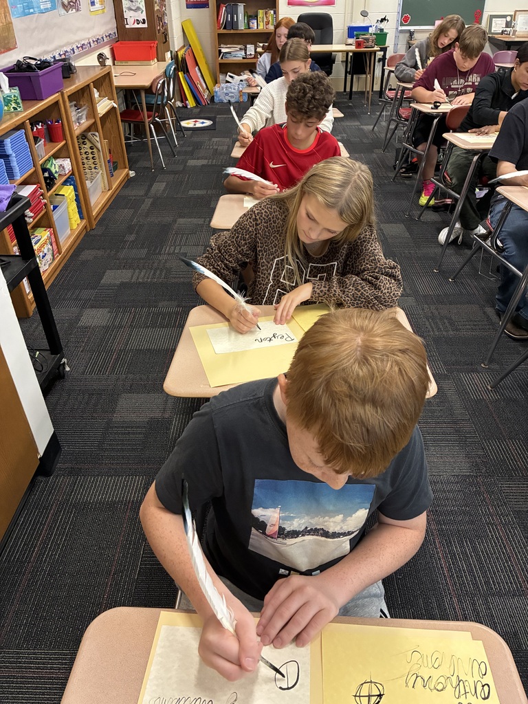 Middle school students writing with quills