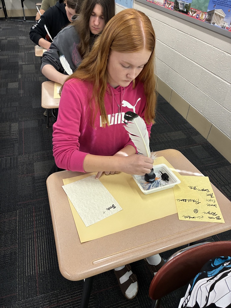 Middle school students writing with quills