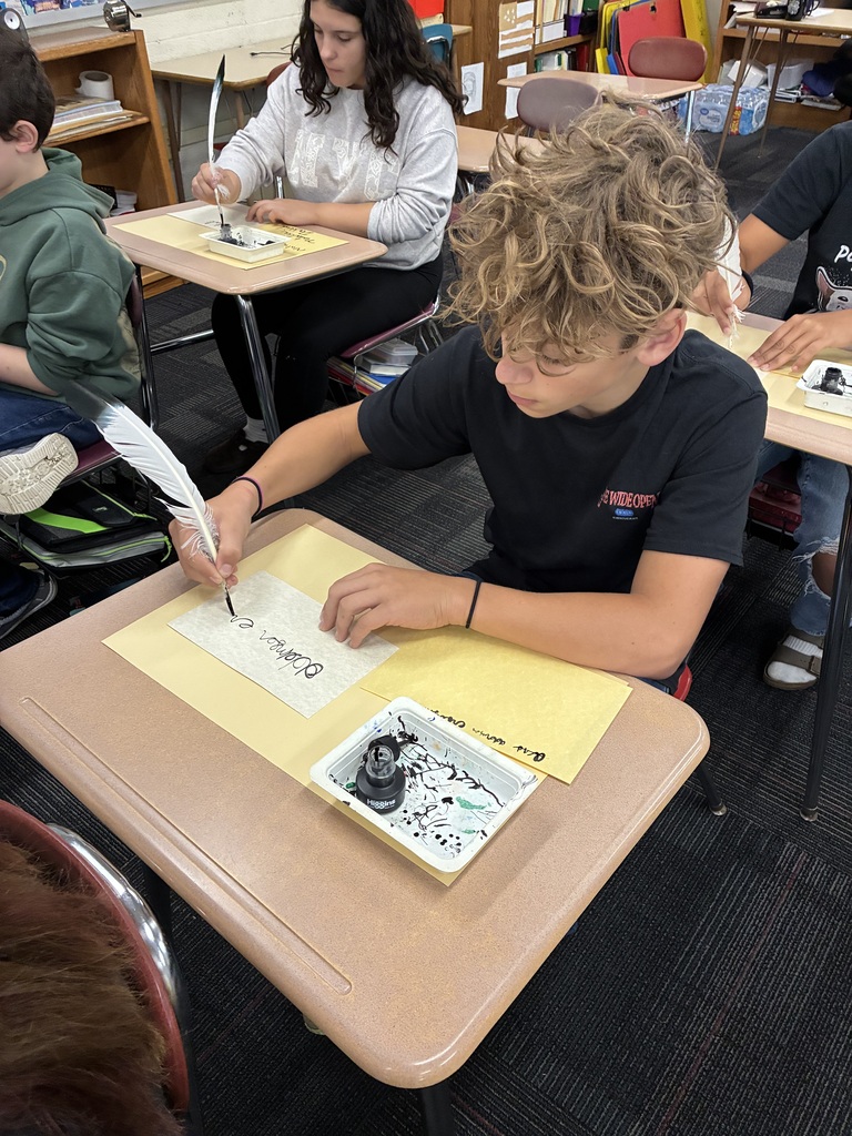 Middle school students writing with quills