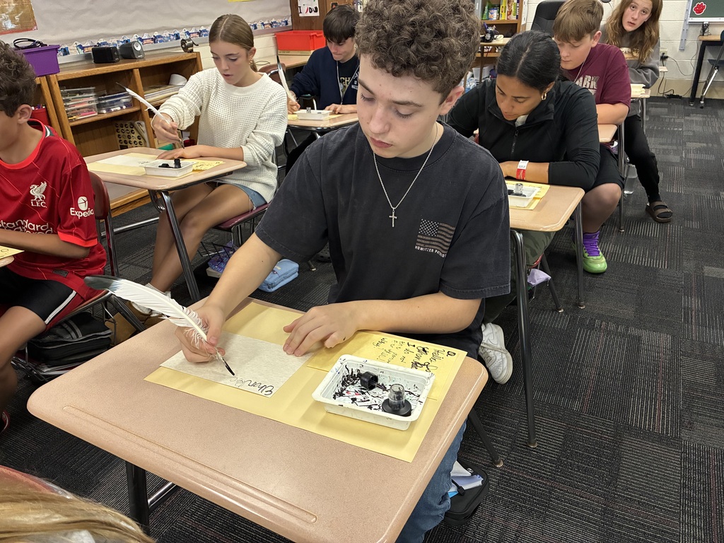 Middle school students writing with quills