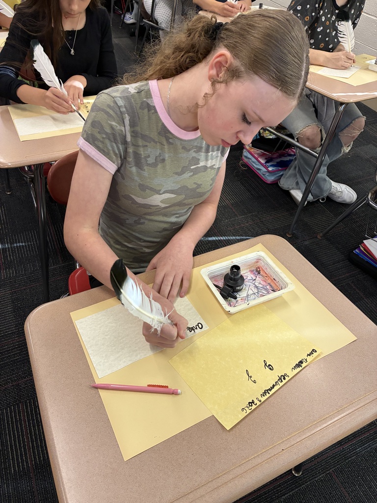 Middle school students writing with quills