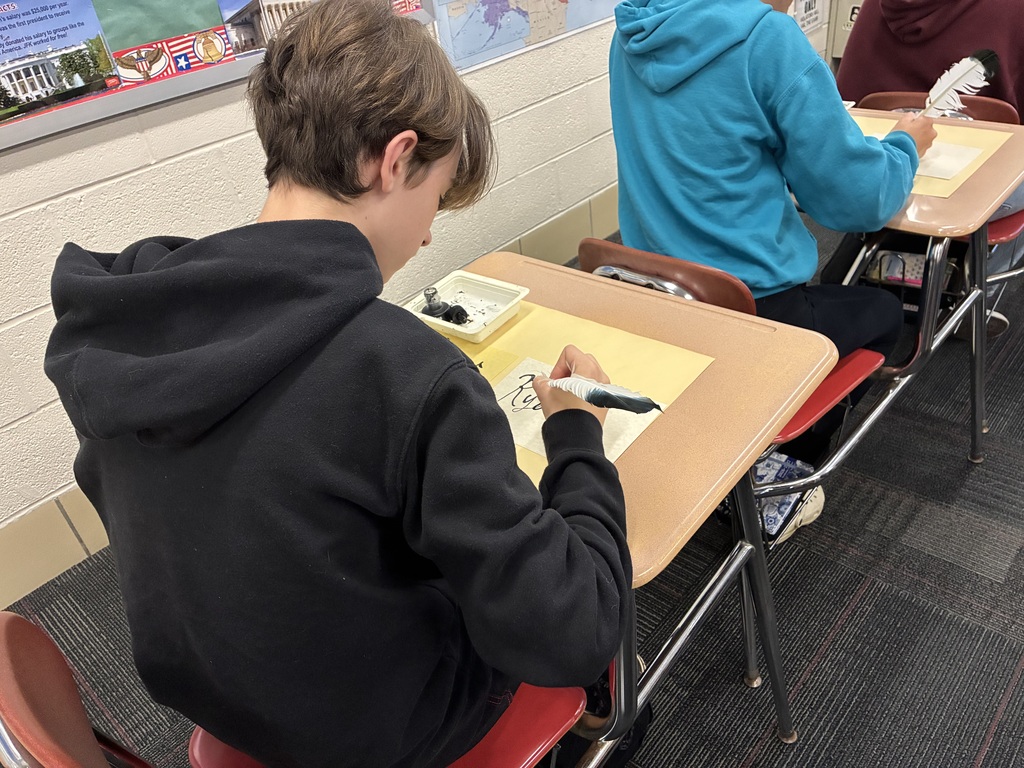 Middle school students writing with quills
