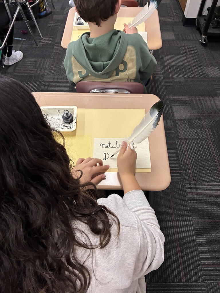 Middle school students writing with quills