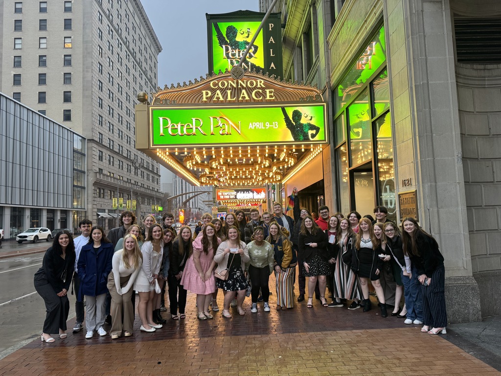 students standing under Peter Pan neon sign at Connor Palace