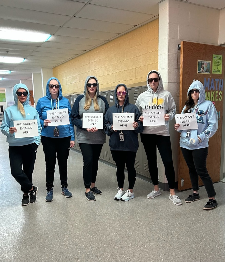 teachers with hoodies on holding signs