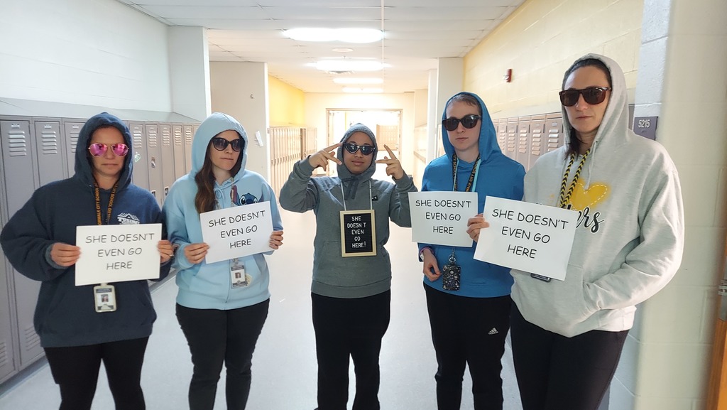 teachers with hoodies on holding signs